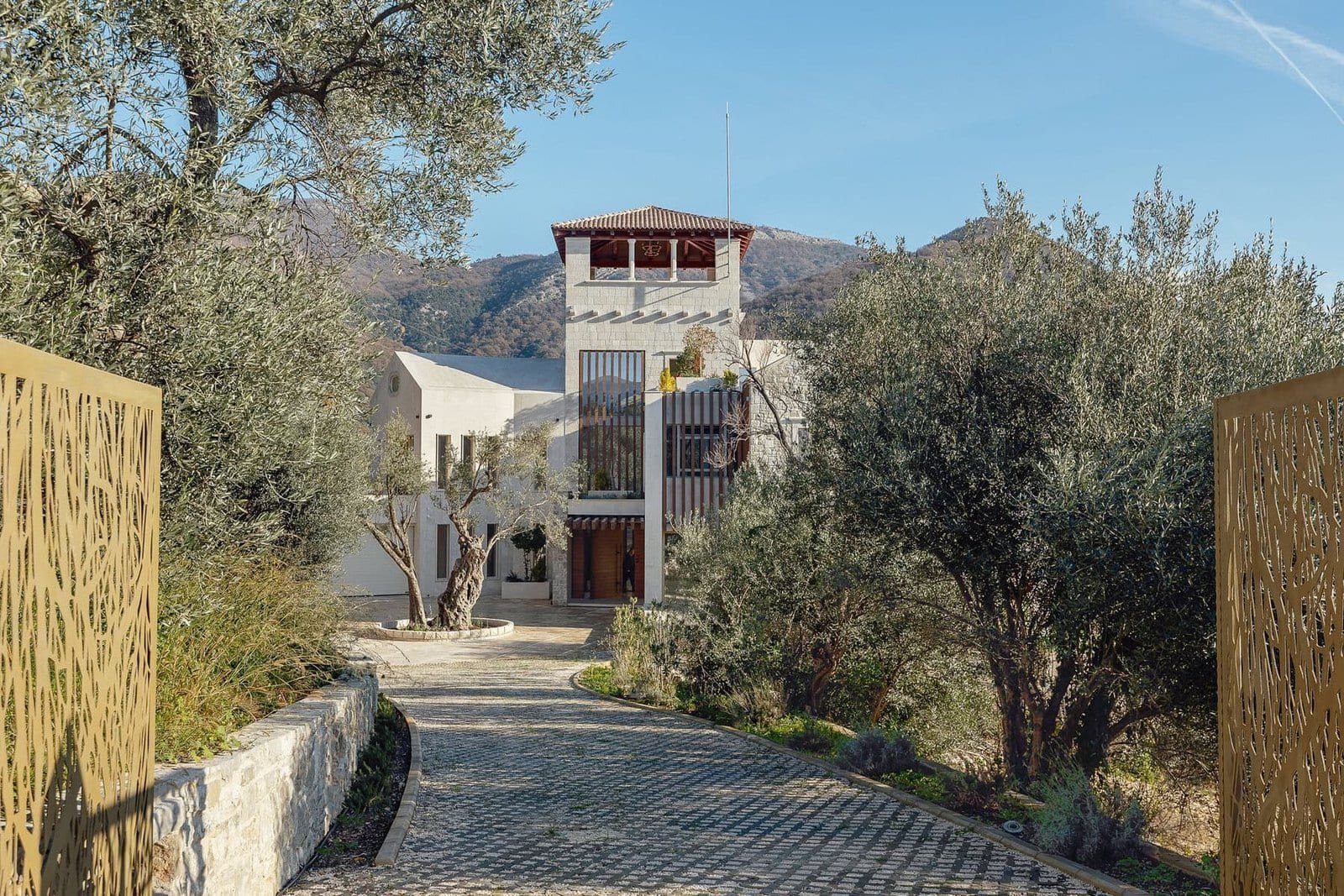 Elegant villa entrance with cobblestone driveway and lush greenery at Barok Estates International.