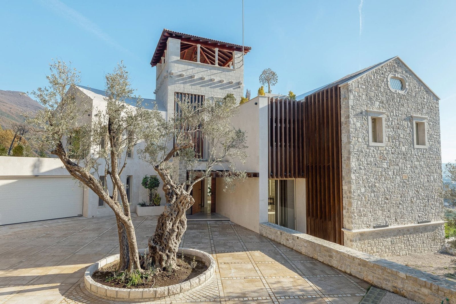 Elegant stone and wood architecture in a scenic mountain setting.
