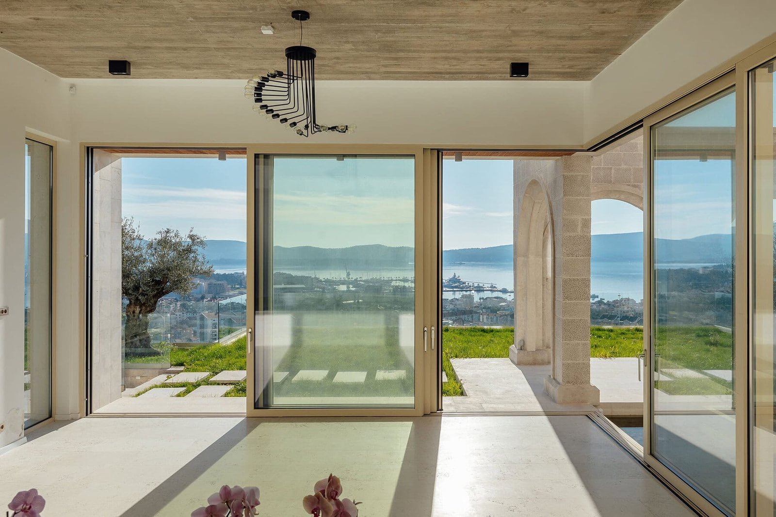 Panoramic sea view from a modern villa with large glass windows and spacious interior.