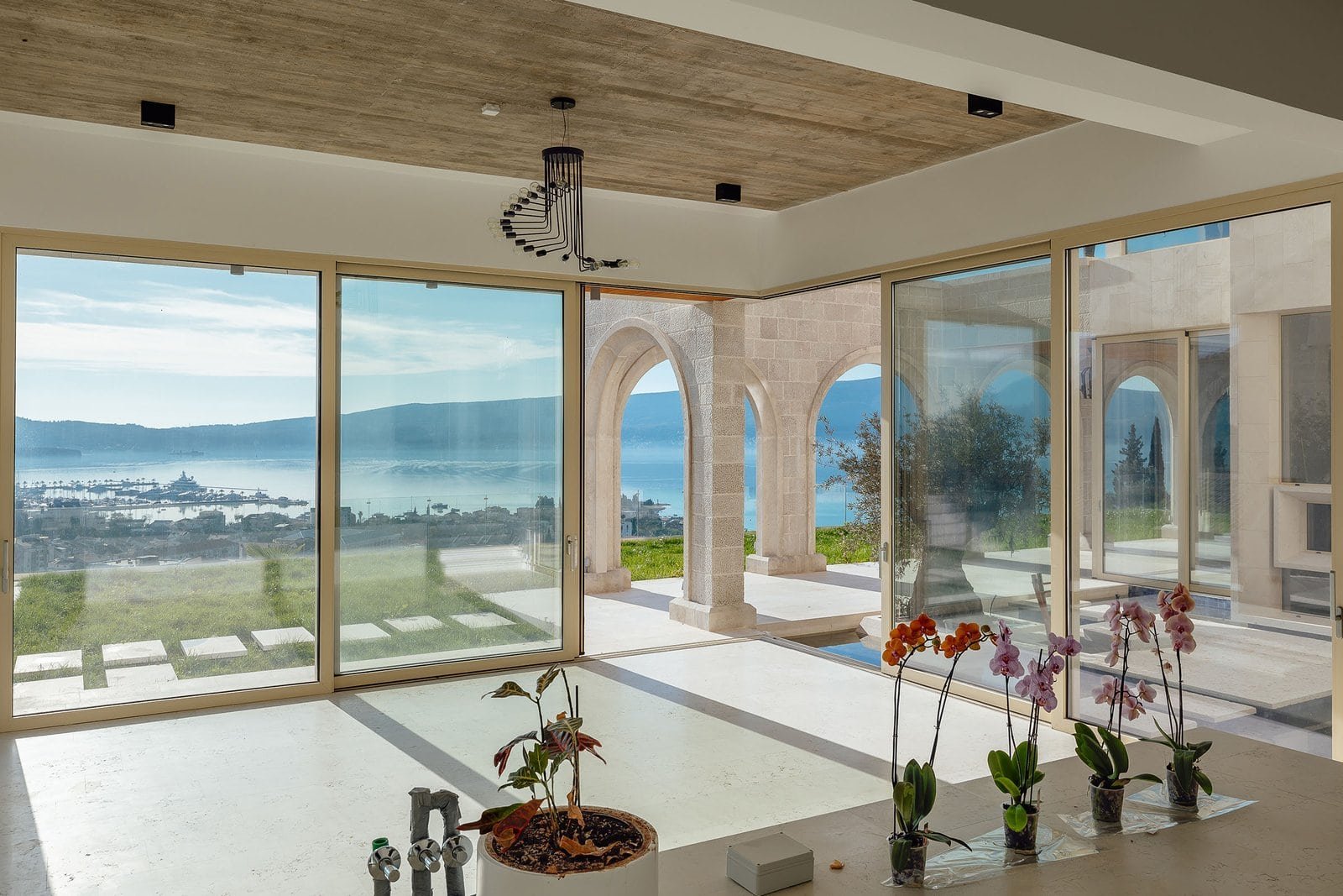 Spacious living room featuring floor-to-ceiling windows overlooking a stunning water landscape, perf.