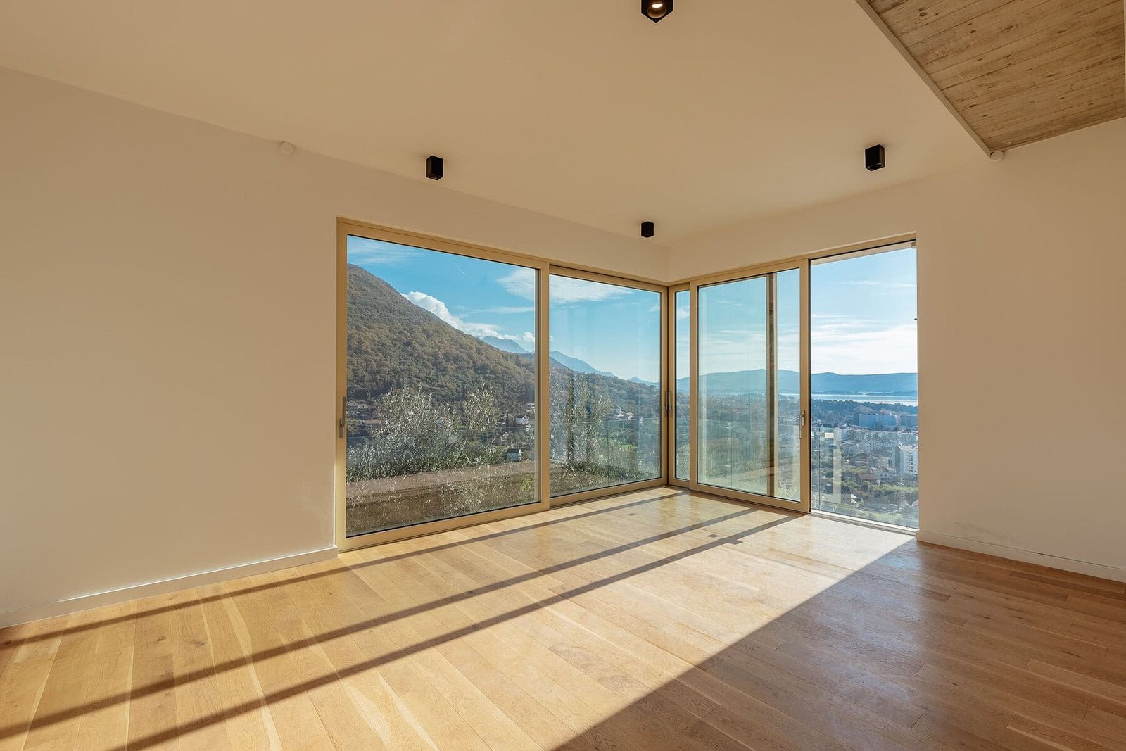 Bright, spacious living room with large windows showcasing mountain and city views.