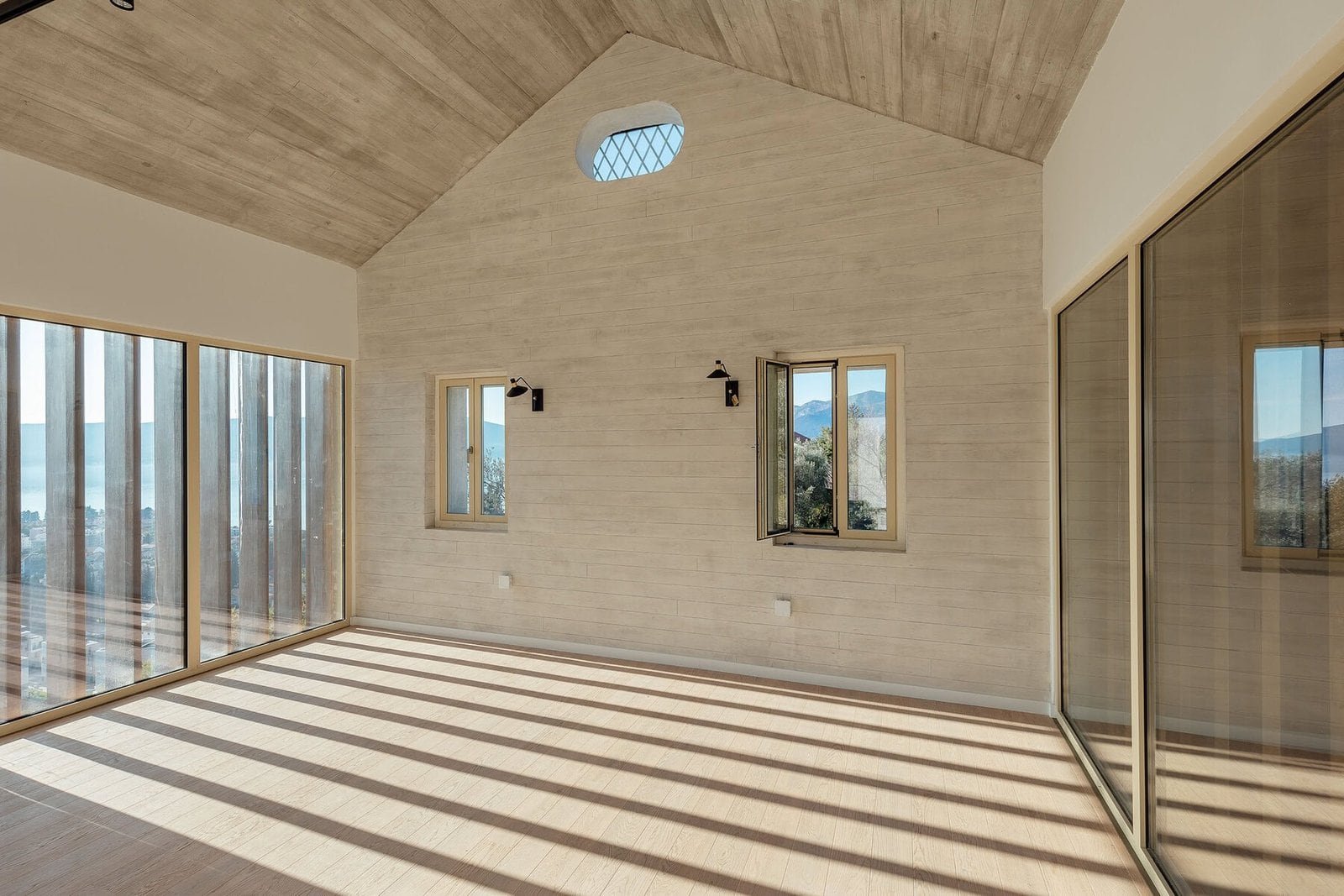 Bright, spacious interior featuring expansive glass windows and a wooden ceiling, ideal for luxury r.