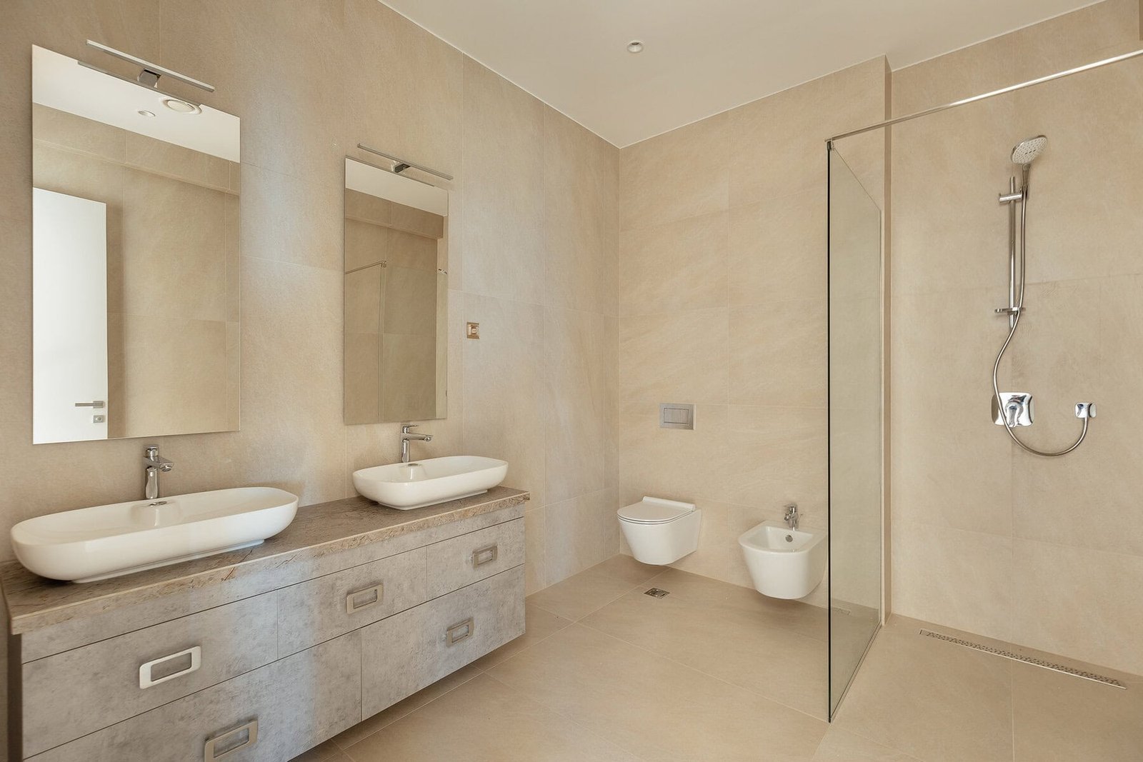 Modern bathroom with dual sinks, walk-in shower, and neutral beige tones.