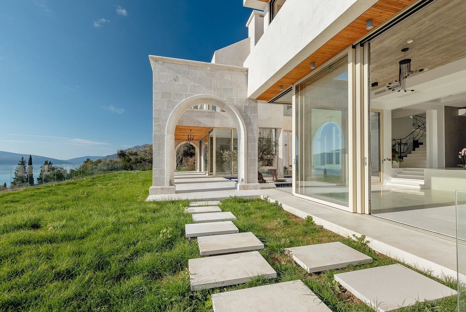 Modern luxury villa with large glass windows and scenic landscape views.
