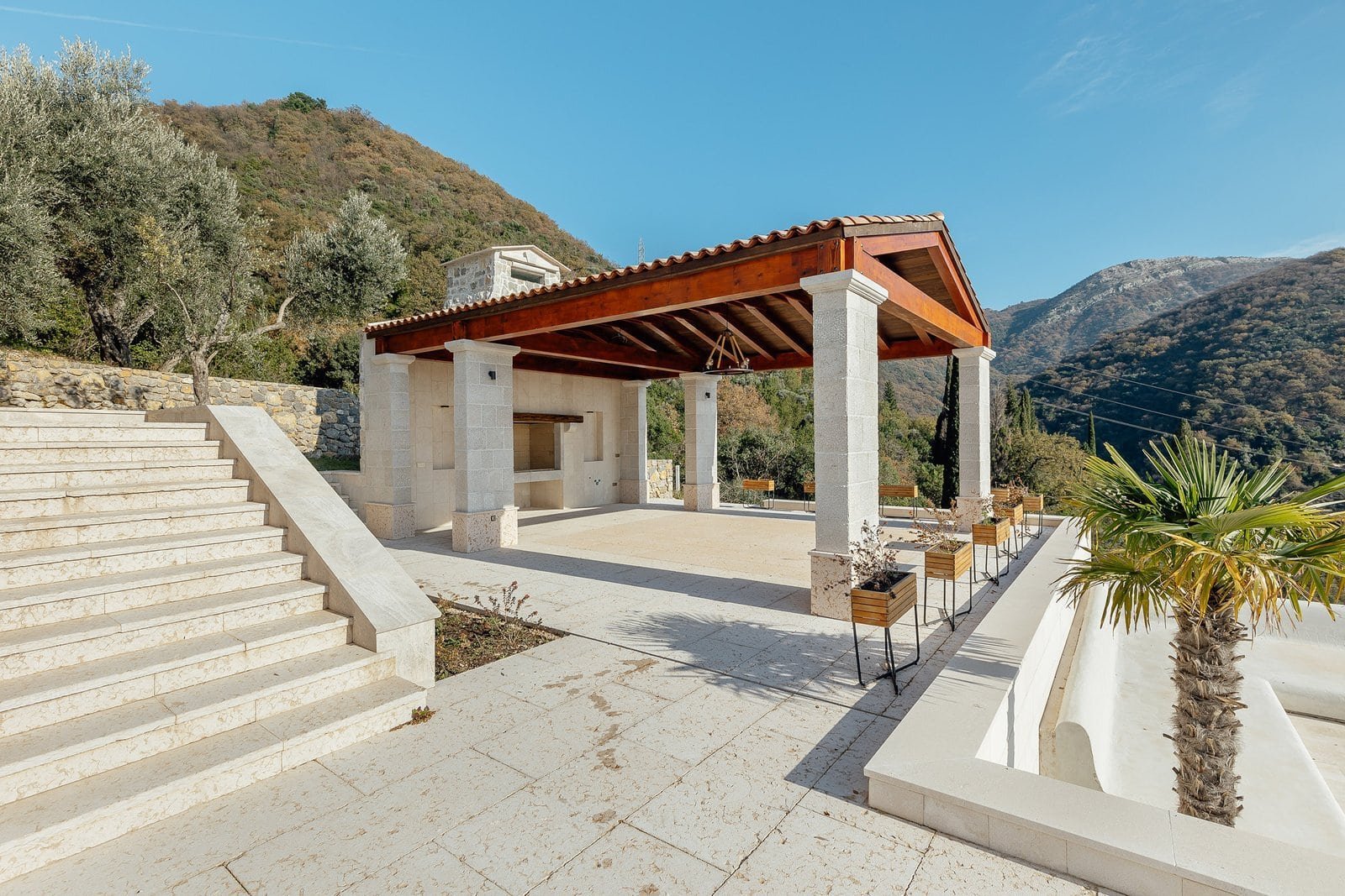 Elegant outdoor lounge with shaded pergola, scenic mountain views, and modern design at Barok Estate.
