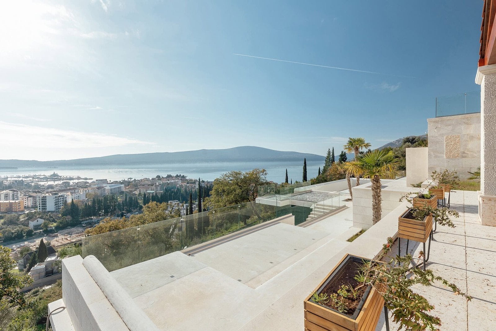 Luxury hillside property with ocean view, modern outdoor terrace, and landscaped garden in a prime l.