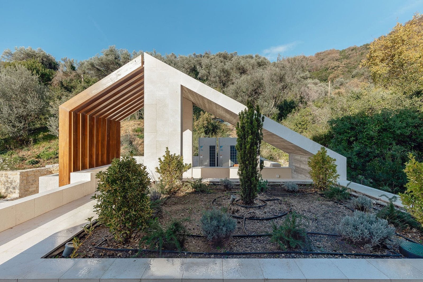 Modern hillside villa with contemporary architecture, lush landscaping, and scenic mountain views in.