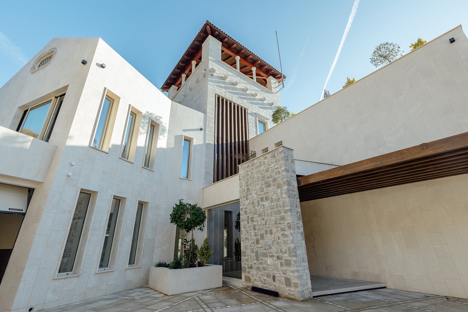 Luxury villa with modern design, white exterior, and stone details.
