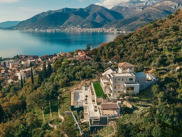 Stunning luxury villa overlooking a serene lake and lush mountains, perfect for exclusive real estat.