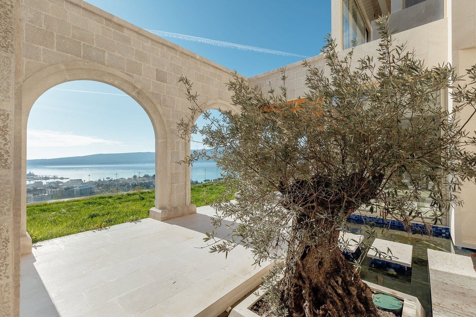 Beautiful coastal view from property with stone archway and olive tree at Barok Estates Internationa.