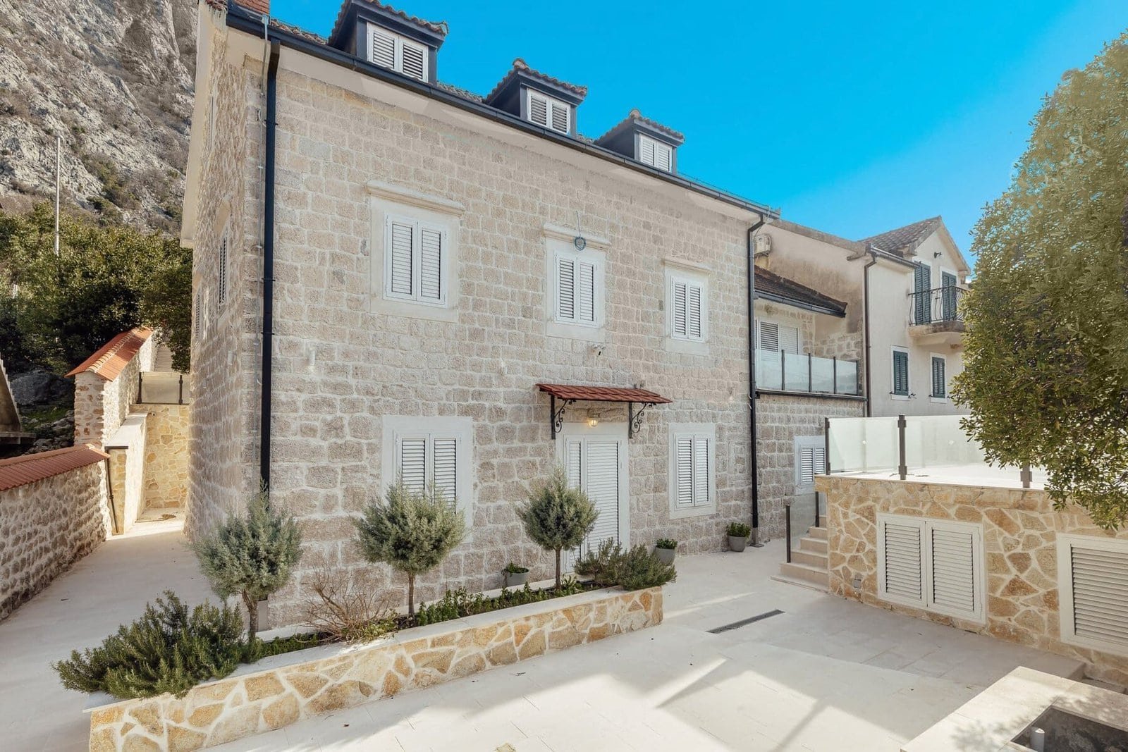 Beautiful stone house with contemporary architecture and lush landscaping.