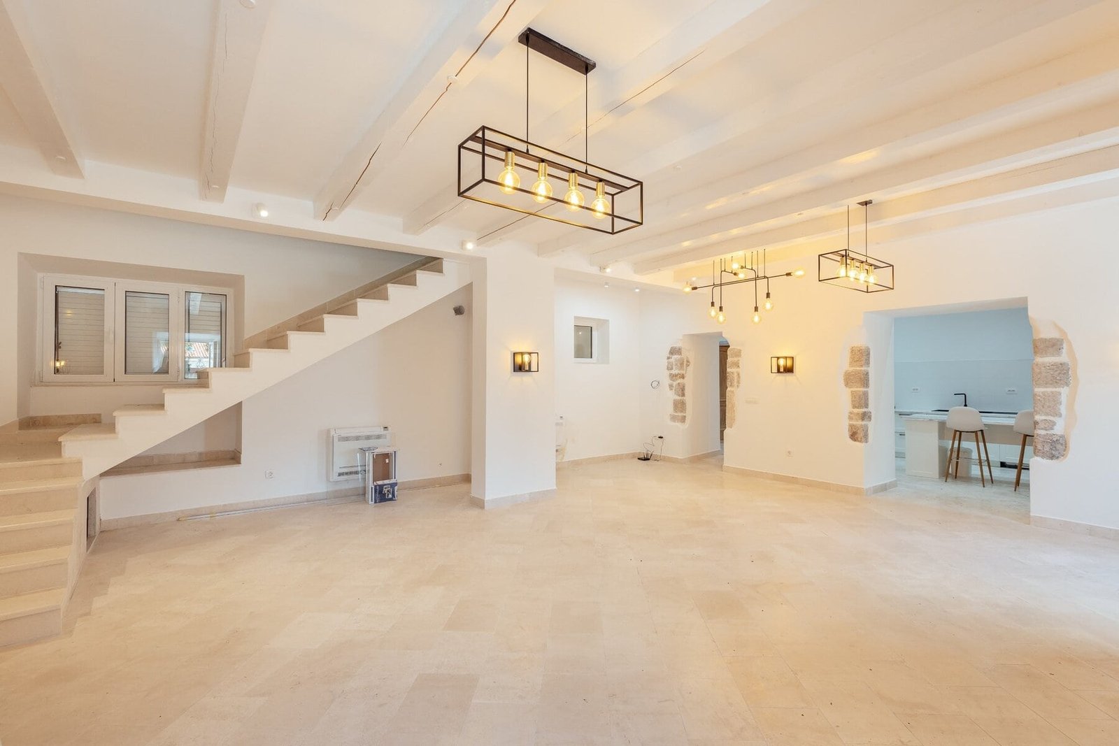 Spacious modern interior featuring open-plan living area, contemporary lighting, and minimalist desi.
