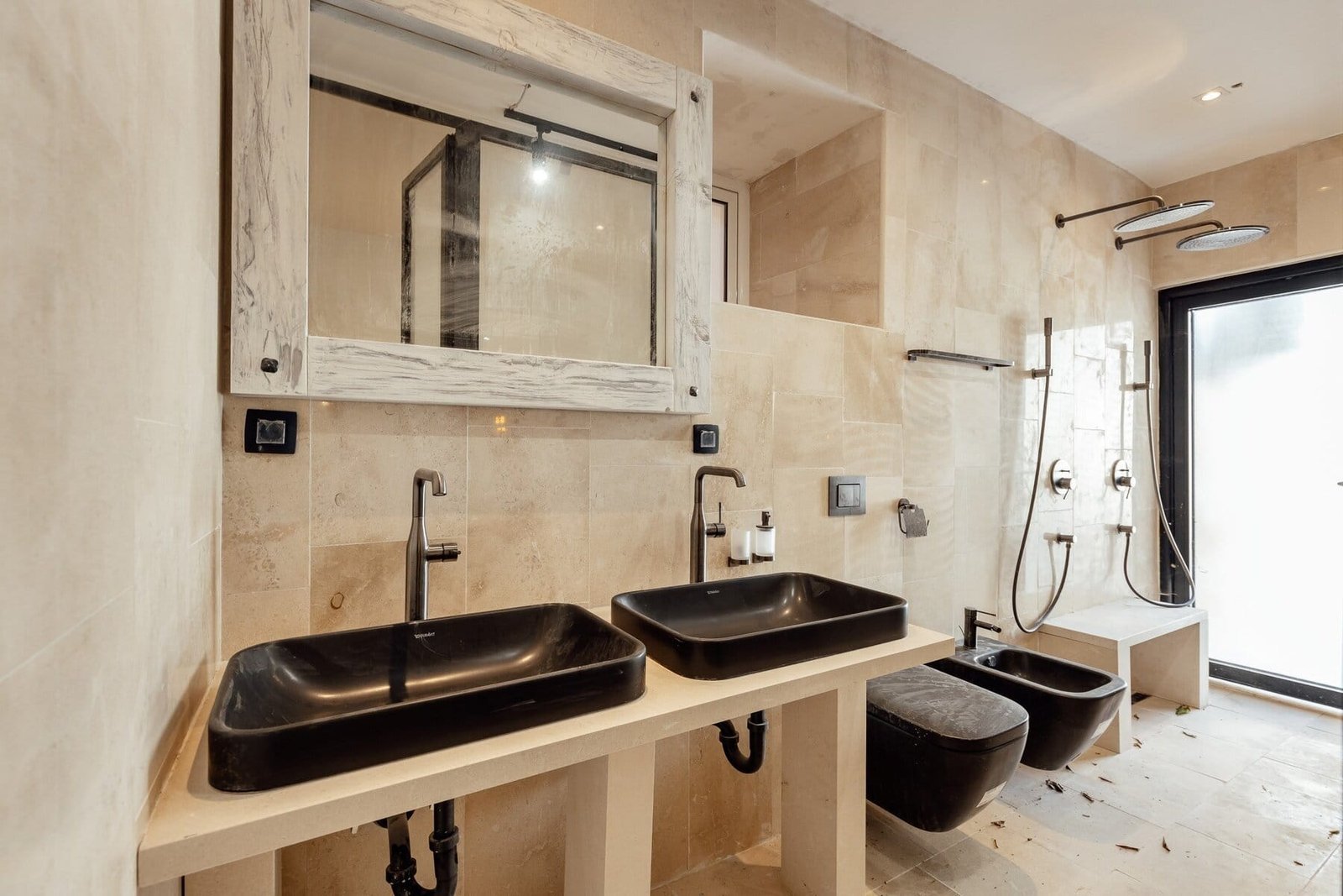 Dual black sinks with modern fixtures in a stylish bathroom.