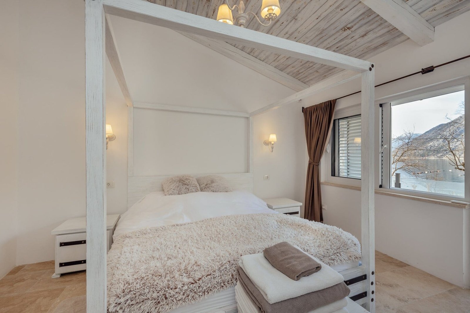 Modern cozy bedroom with canopy bed and natural light.