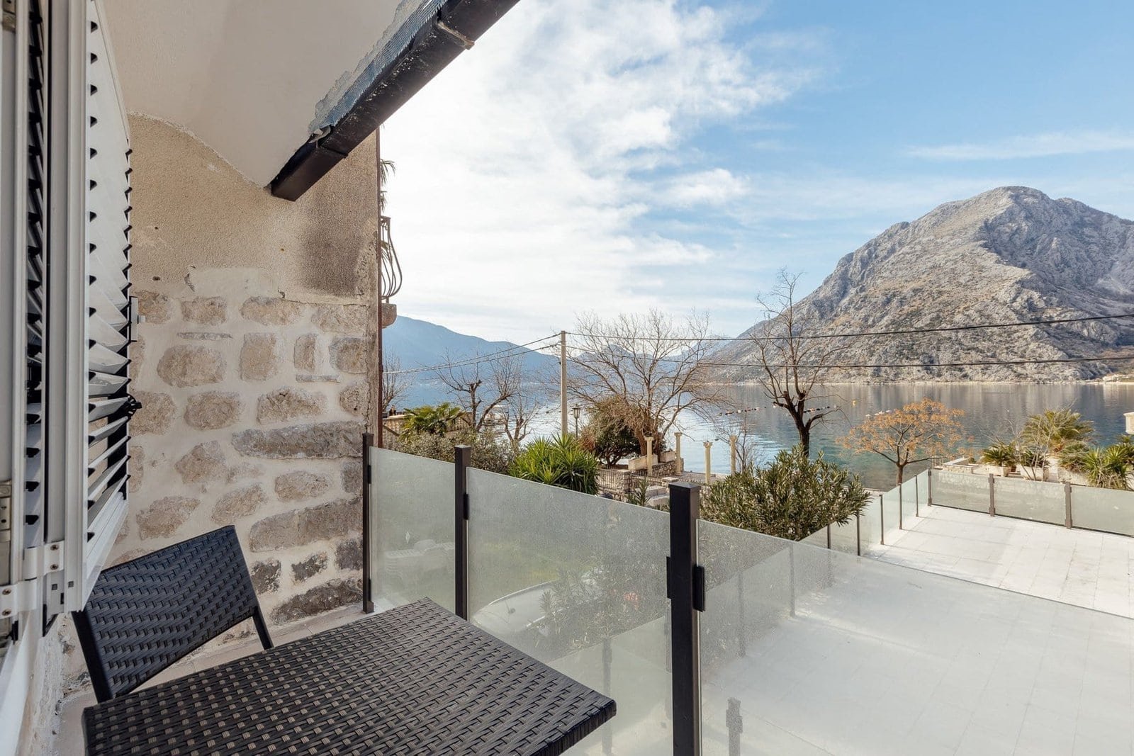 Balcony overlooking a tranquil lake and majestic mountains, perfect for relaxing and enjoying nature.