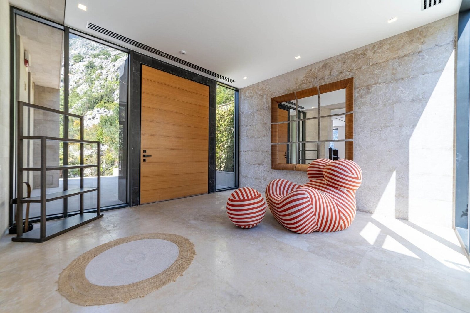 Elegant contemporary entryway featuring minimalist design and large glass doors.
