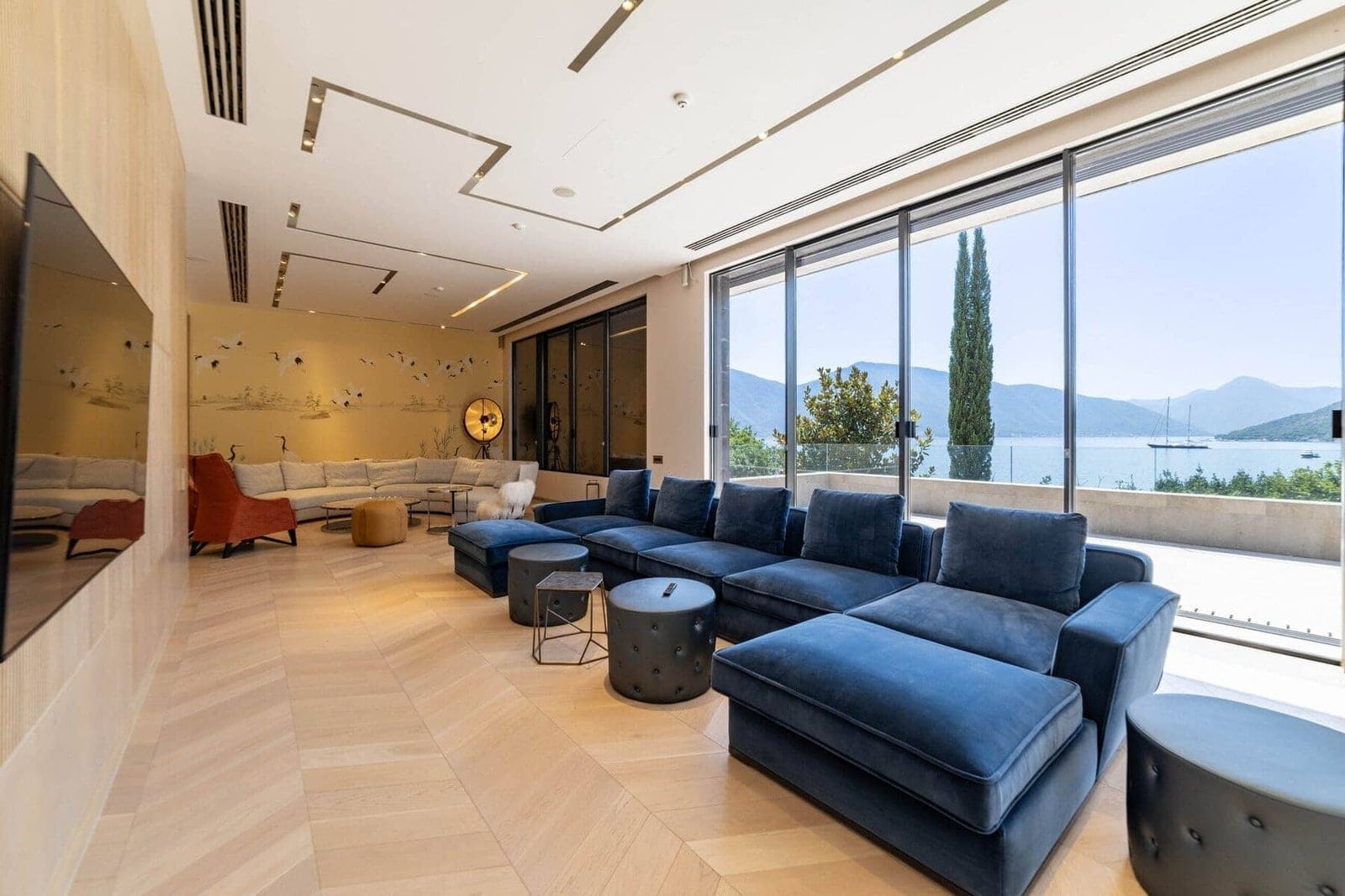 Elegant interior of a contemporary living room overlooking a scenic lake and mountains. Spacious sea.