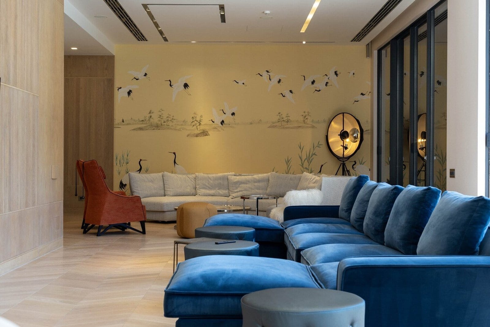 Elegant hotel lobby with plush blue and beige seating, wall art, and contemporary design.