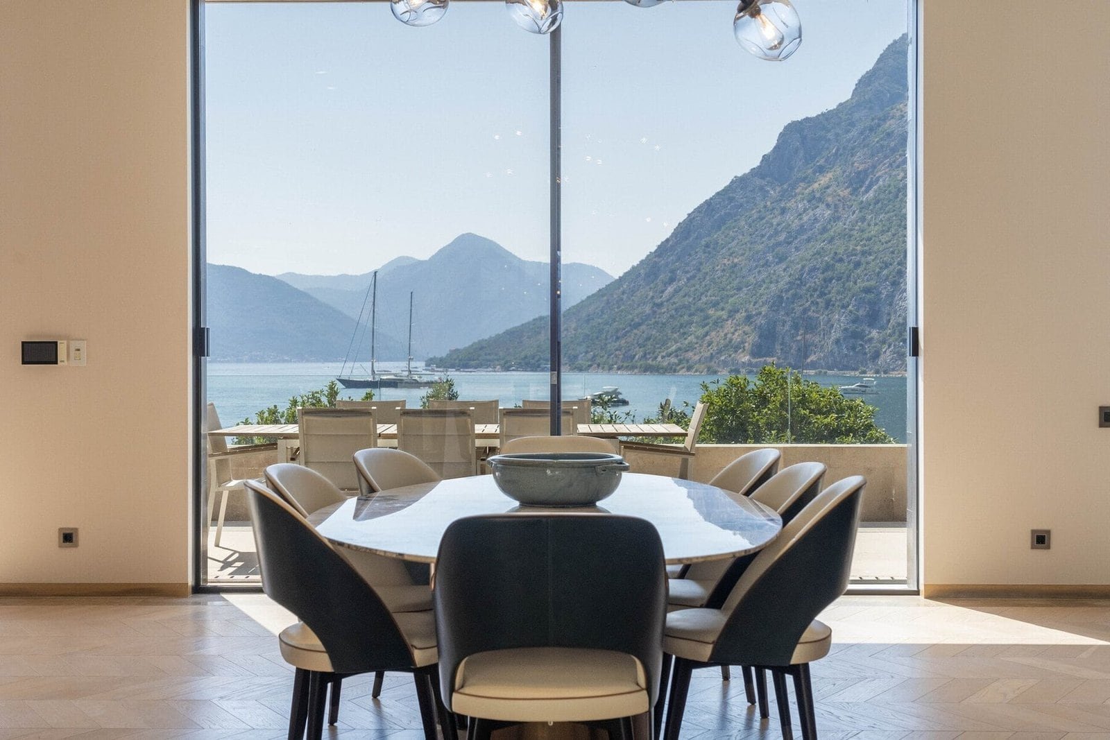 Lakeside dining room with mountain view, large glass windows, and elegant table setting at Barok Est.