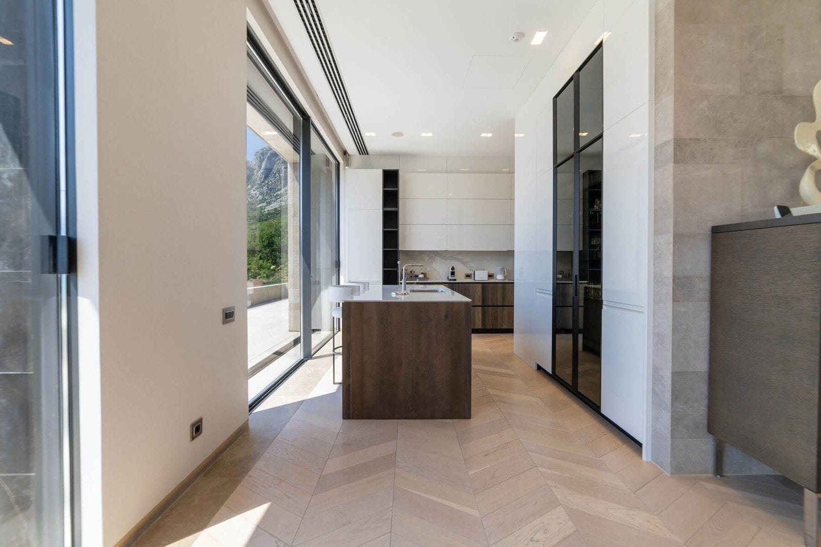 Bright, airy kitchen featuring large windows, modern cabinetry, and a central island for cooking and.