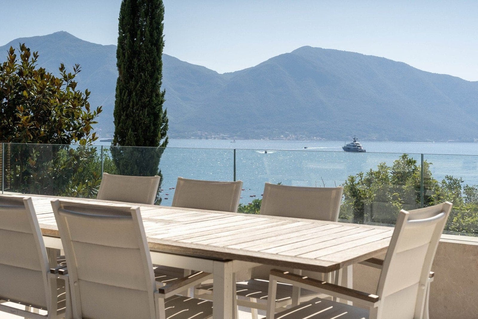 Outdoor dining space overlooking scenic lake and mountain landscape.