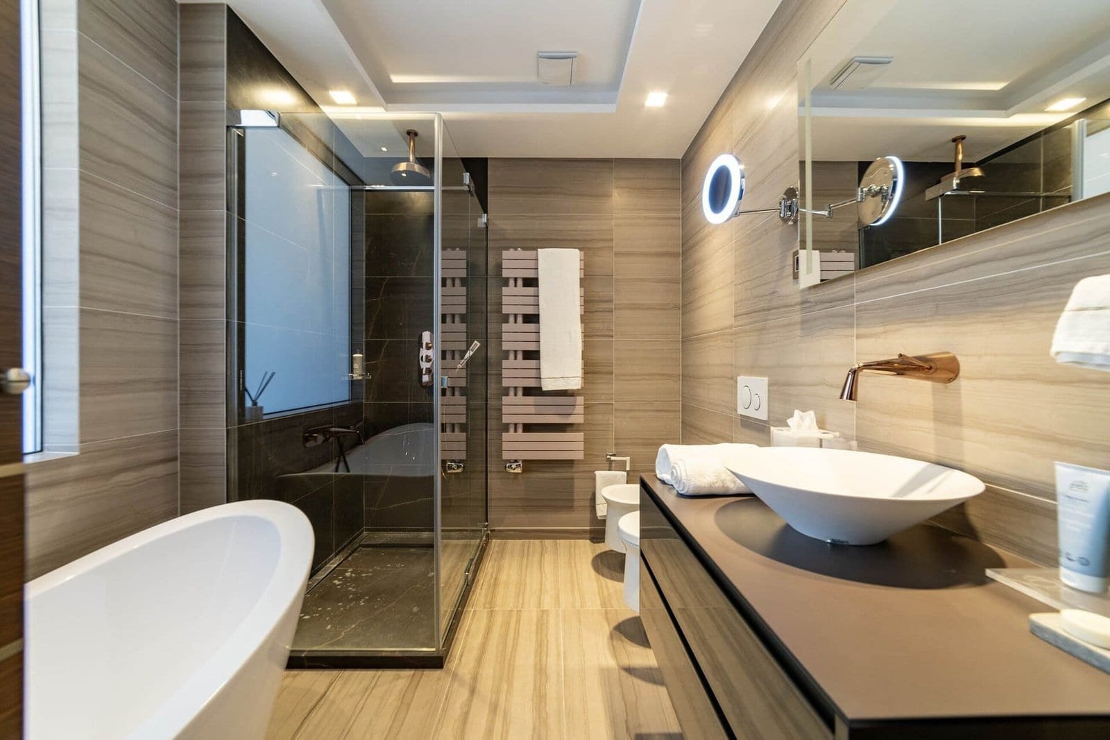 Elegant bathroom featuring a walk-in shower, bathtub, and contemporary fixtures.