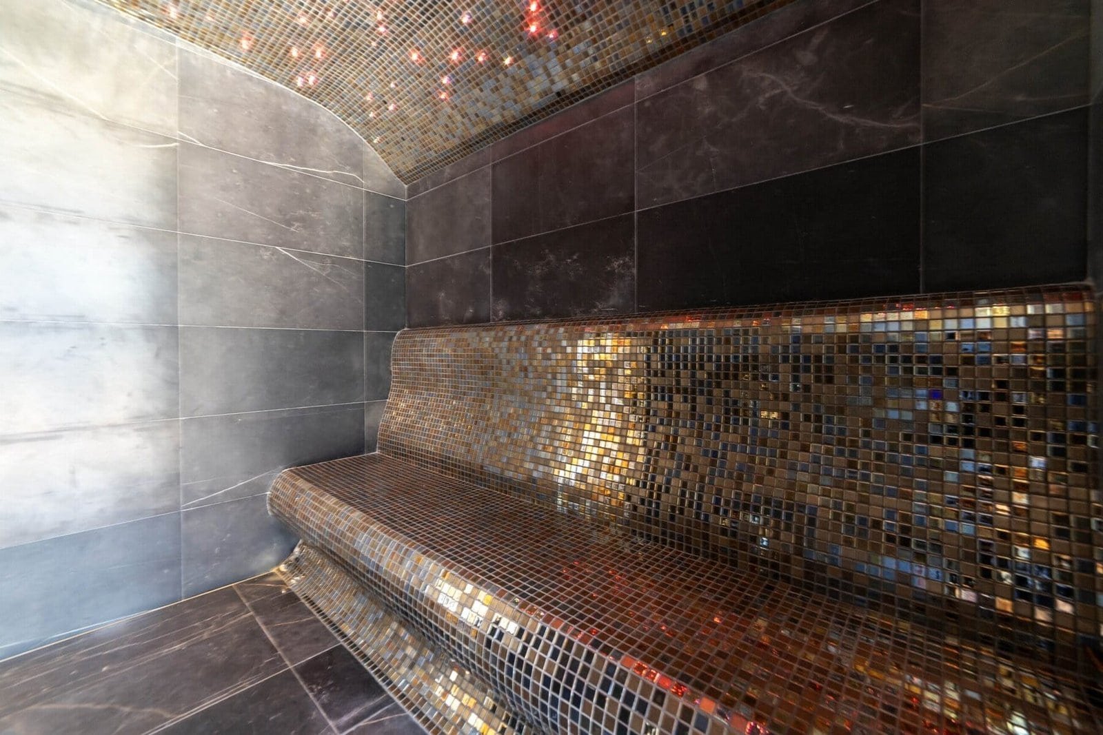 Elegant spa seating with mosaic tiles and modern design.