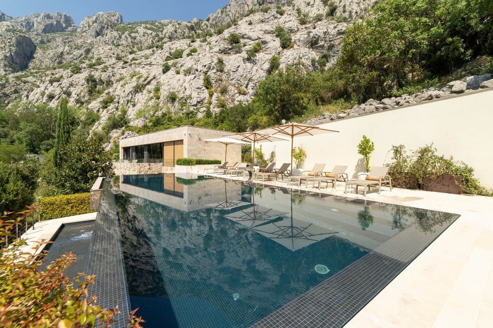 Infinity pool overlooking mountain landscape at luxury villa.