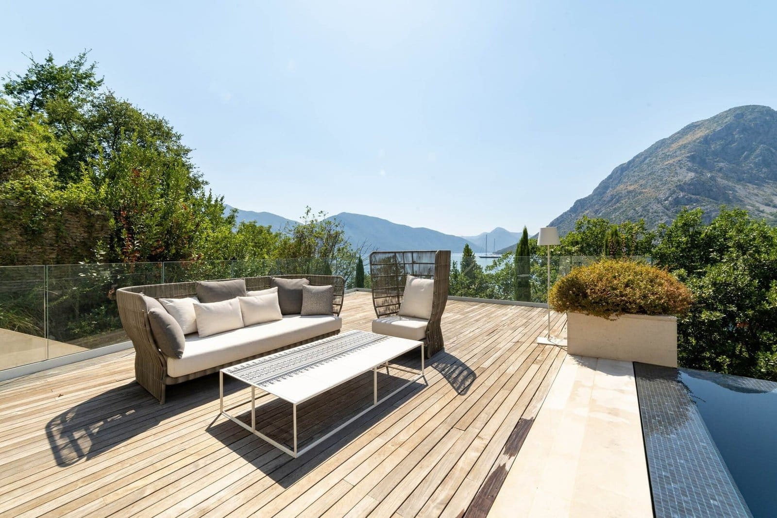 Modern outdoor deck with seating and mountain scenery in the background.