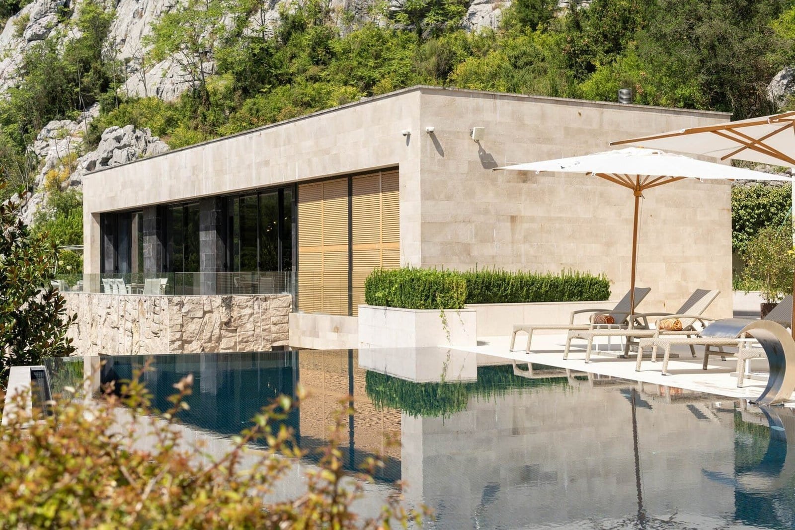 Luxury villa with pool, outdoor lounge, and scenic natural surroundings.