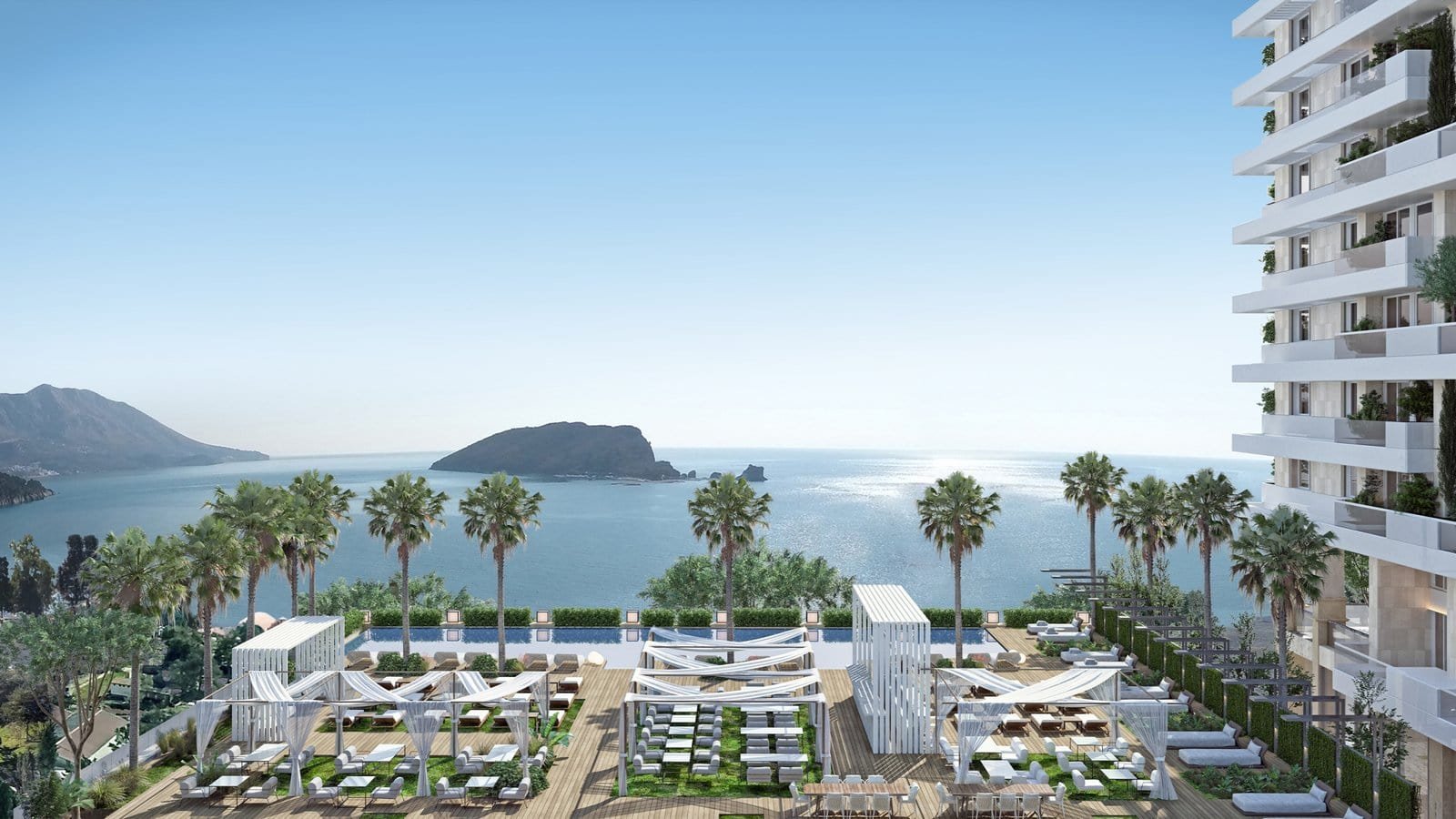 Modern seaside residential complex with ocean views and palm trees in a tropical setting.