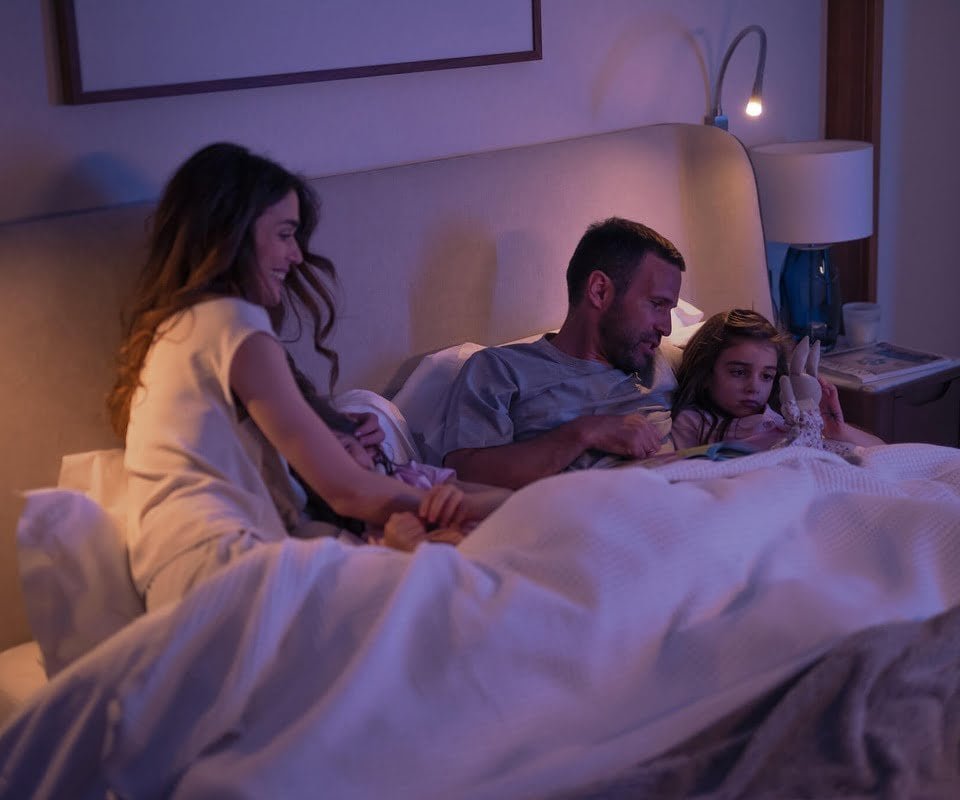 Een gezin dat samen geniet van het slapengaan in een gezellige, warm verlichte slaapkamer.
