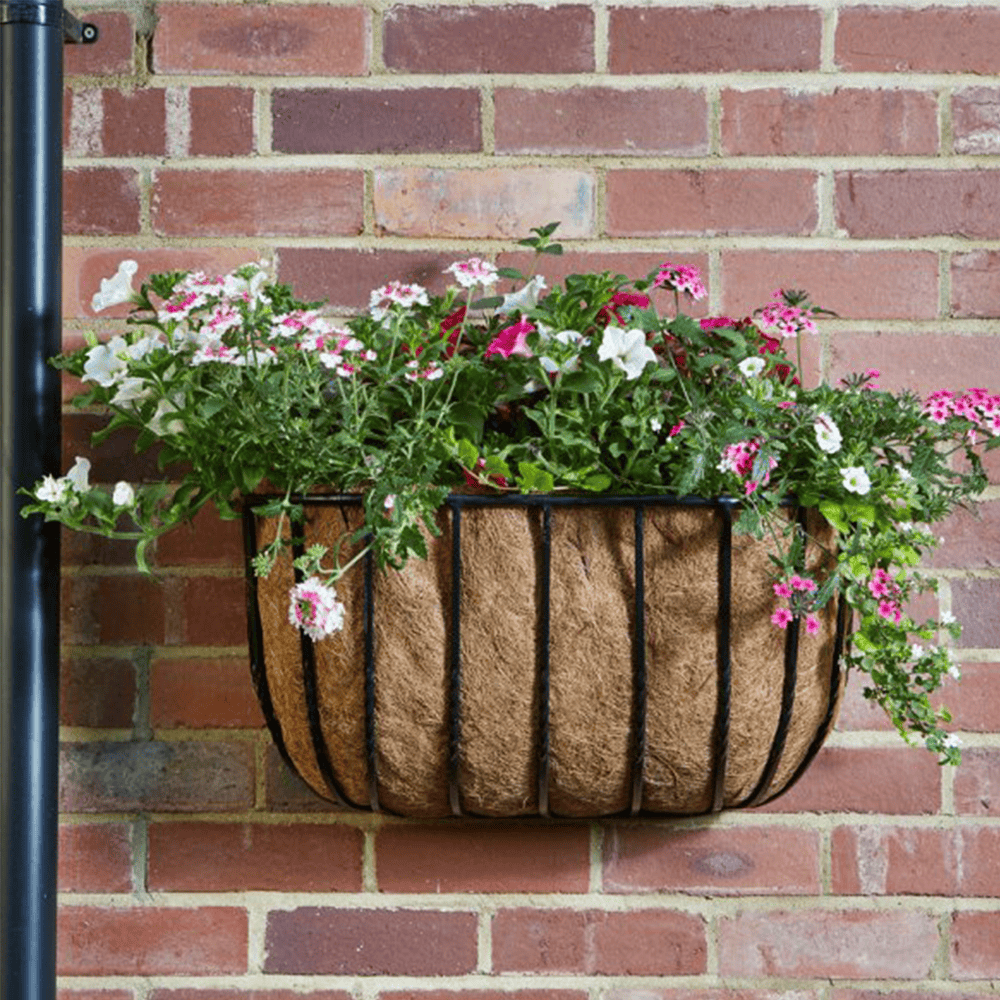 Flowers in a basket hanging on a brick wall, showcasing gardening and floral display.