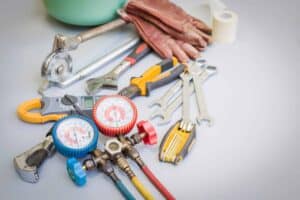 Essential tools—wrenches, pliers, gauges, gloves, and a pipe cutter—symbolize expert 24/7 Utah home repair by trusted pros.