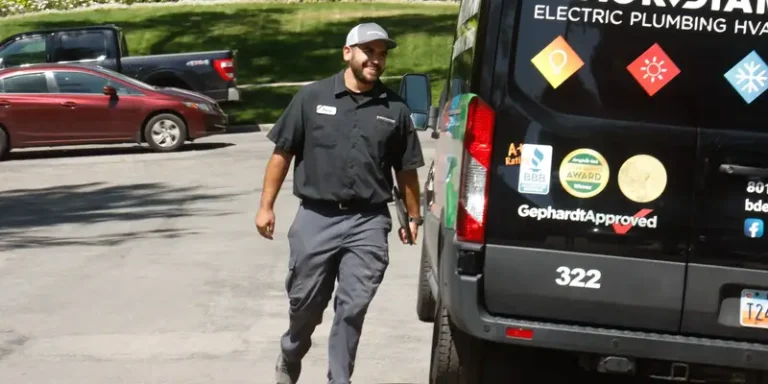 A professional in uniform approaches a Black Diamond Experts van, ready to provide trusted 24/7 plumbing, HVAC, and electrical care.