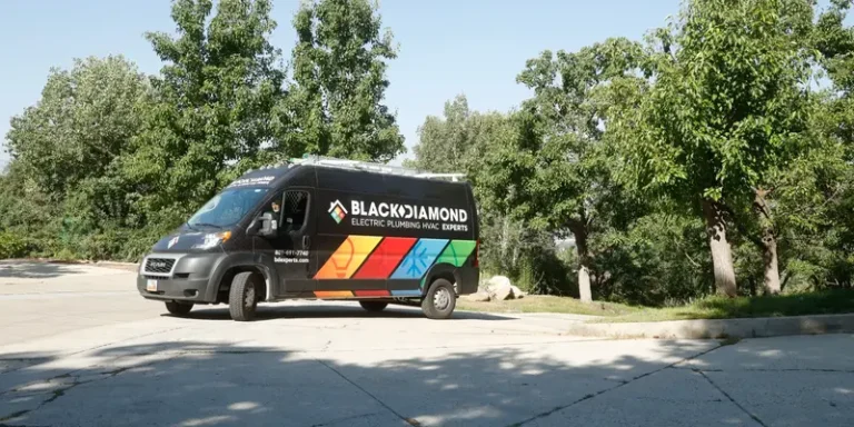 A Black Diamond Experts van, parked amid trees, highlights 24/7 trusted plumbing, HVAC, electrical & drain services across Utah.