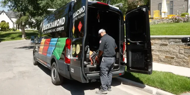 A helpful Black Diamond technician readies tools by their van, providing expert 24/7 HVAC, plumbing, and electrical service in Utah.