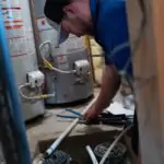 A trusted Black Diamond Expert plumber ensures safe, reliable repairs on pipes in a utility room with water heaters nearby.