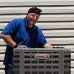 A skilled technician in a blue shirt and cap inspects an outdoor Lennox AC unit, ensuring Utah homes have safe, reliable comfort.