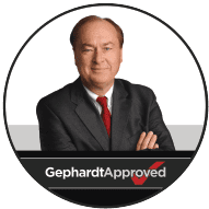 A man in a suit with folded arms stands in front of a white background. Text at the bottom reads "Gephardt Approved" with a red check mark.