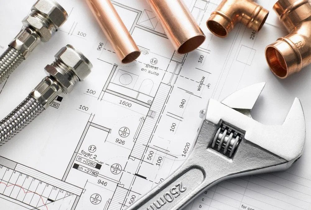 Plumbing tools, copper pipes, and fittings on blueprints highlight Black Diamond Experts’ trusted 24/7 home comfort solutions.