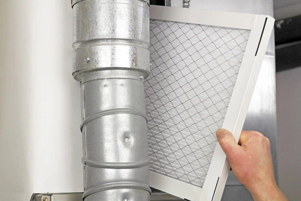 A caring expert replaces an air filter by an air duct, ensuring clean air and comfort—trust Black Diamond for 24/7 home service.