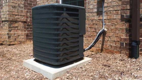 A sturdy outdoor AC unit sits securely by a brick home, expertly installed for 24/7 comfort by Utah’s trusted service experts.