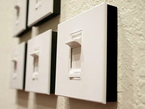 Close-up of crisp white light switches on a textured wall, reflecting expert, reliable service and 24/7 home comfort in Utah.