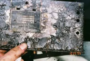 A hand displays a fire-damaged metal plate with a faint label, reflecting our commitment to safe, reliable 24/7 home repairs.