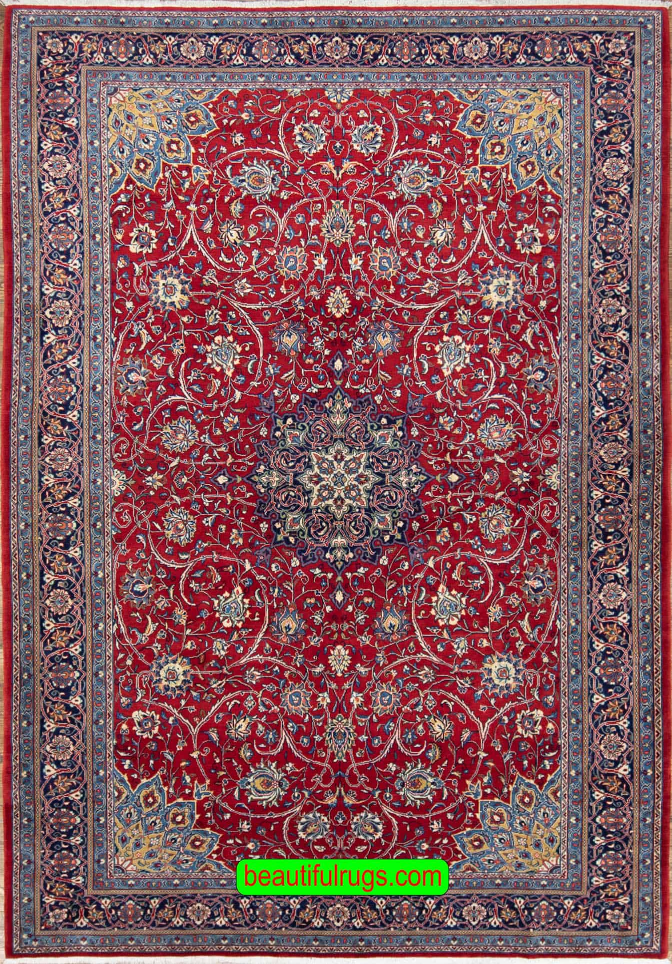 Hand knotted Persian Sarouk area rug with red and navy blue made of wool. Size 7.1x10.4.