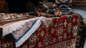 A red rug and kilim rugs are placed on a bench.