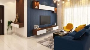 living room marble floor and blue couch with yellow chair, television is installed on the wall.