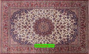 An antique Persian Isfahan rug with beige color in the main field and red in the borders.
