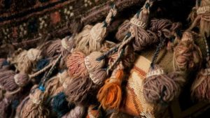Sample wool fiber in brown, orange and beige colors are bundled together.